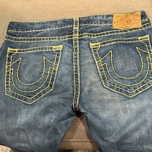 Blue men’s True Religion jeans with light stitching.